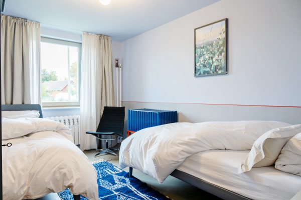 Im kleinen Schlafzimmer kommst du zur Ruhe in den zwei Einzelbetten von Auping.